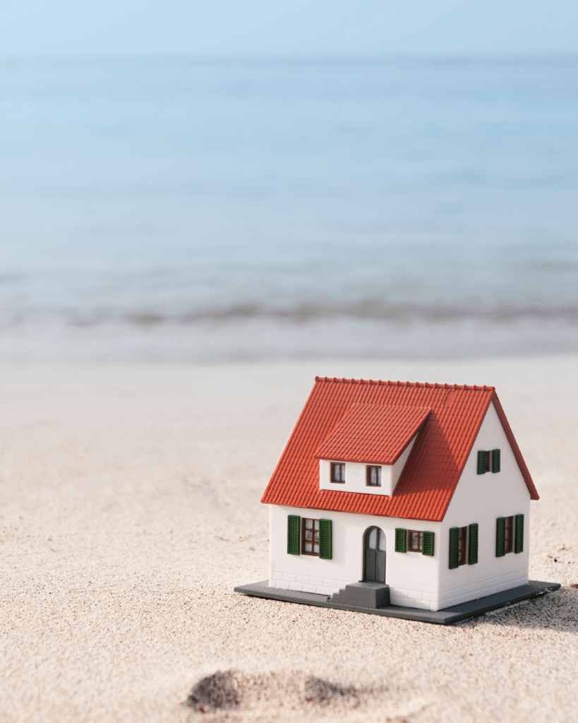 Modellino di una casa sulla spiaggia che rappresenta una seconda casa al mare